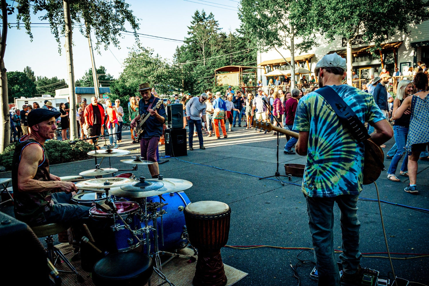 Street performance with musicians from band ROSS-a-CONN playing drums and guitar in a public area on Whidbey Island.