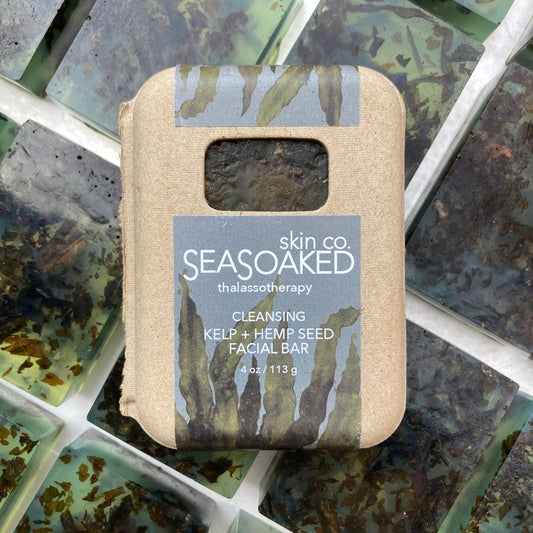 The product (a bar of seaweed soap) in a brown paper box, sitting on top of many bars of the soap.