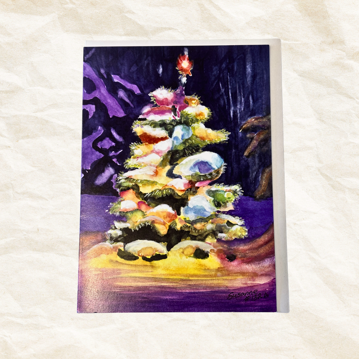 Colorful Christmas tree painting on a textured white surface