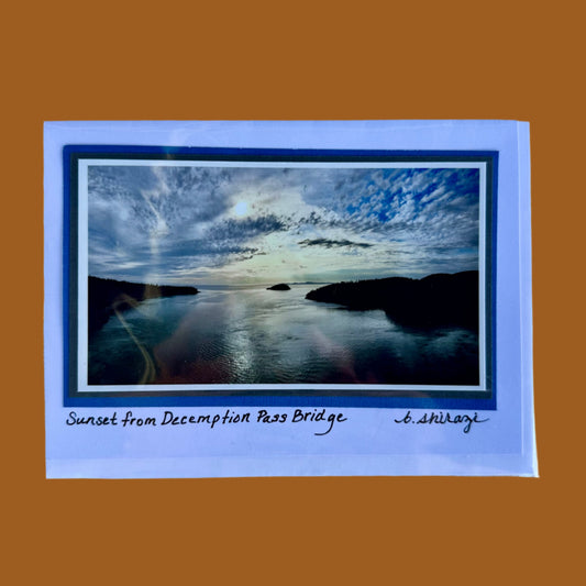 Photo of the sunset from Deception Pass Bridge, attached to a white greeting card with the handwritten words "Sunset from Deception Pass Bridge, B Shirazi"
