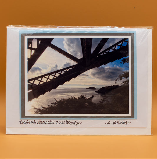 Photo of Deception Pass Bridge, attached to a white greeting card with the handwritten words "Under the Deception Pass Bridge, B Shirazi"