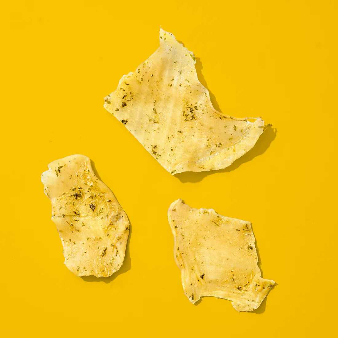Three yellow-ish calamari pieces on a yellow background