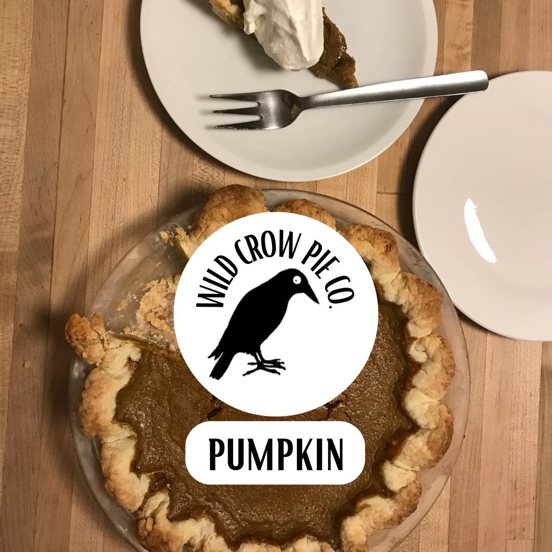 Pumpkin pie with Wild Crow Pie Co. logo on a wooden table