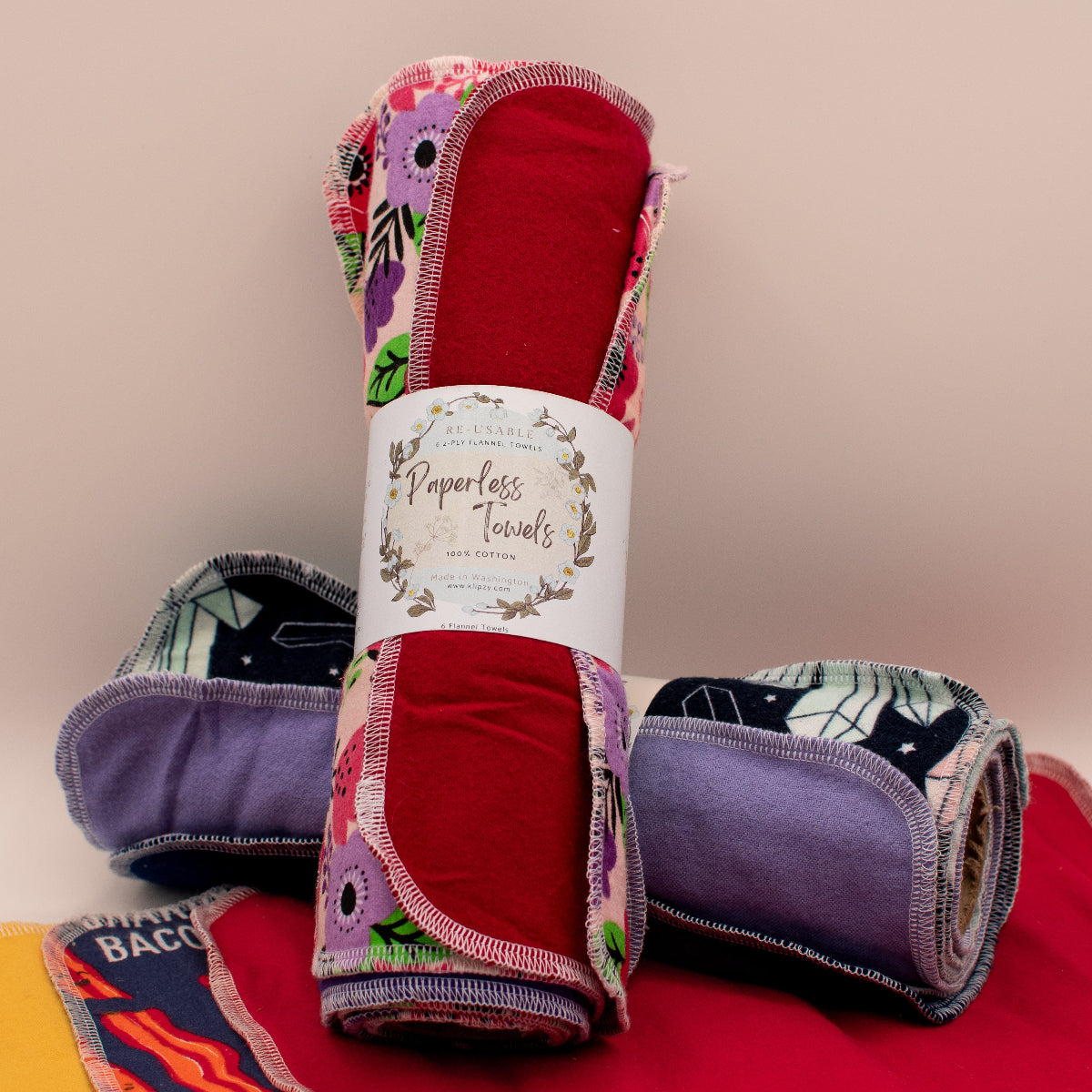 A stack of various reusable paperless towels with different designs, featuring floral and geometric patterns, placed against a white background.