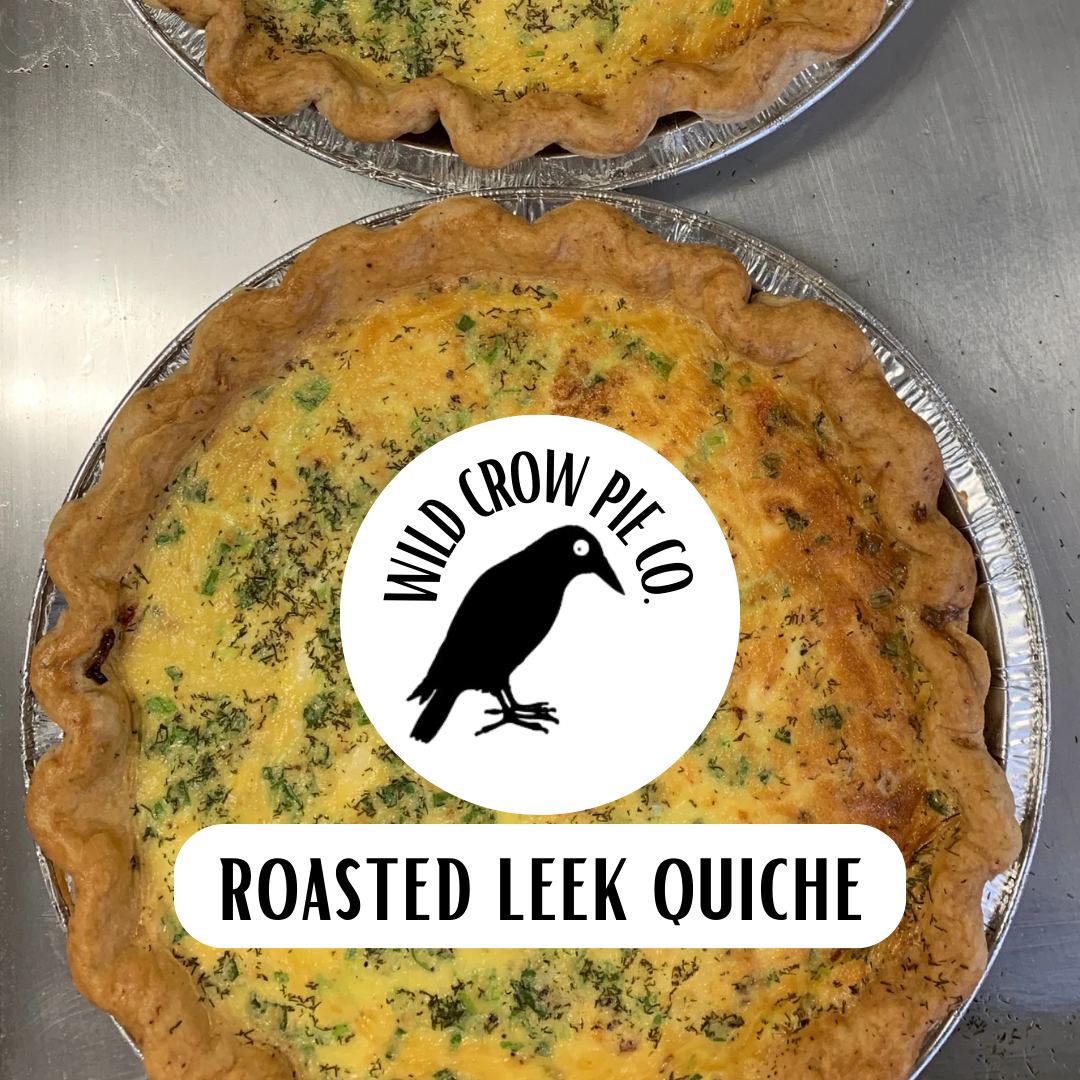 Roasted leek quiche with Wild Crow Pie Co. branding on a metal tray.