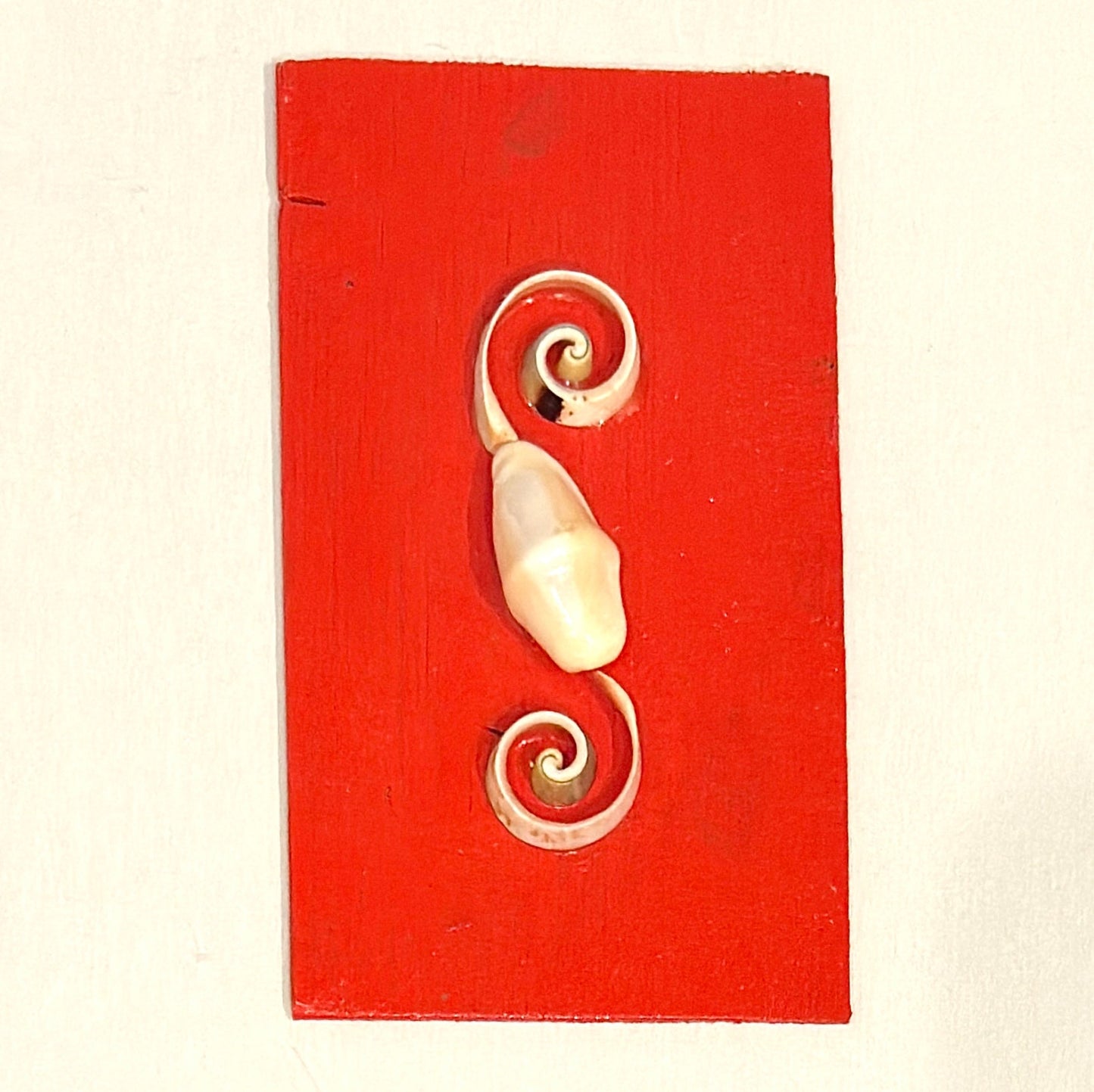 Decorative wall hook with spiral design on a red background