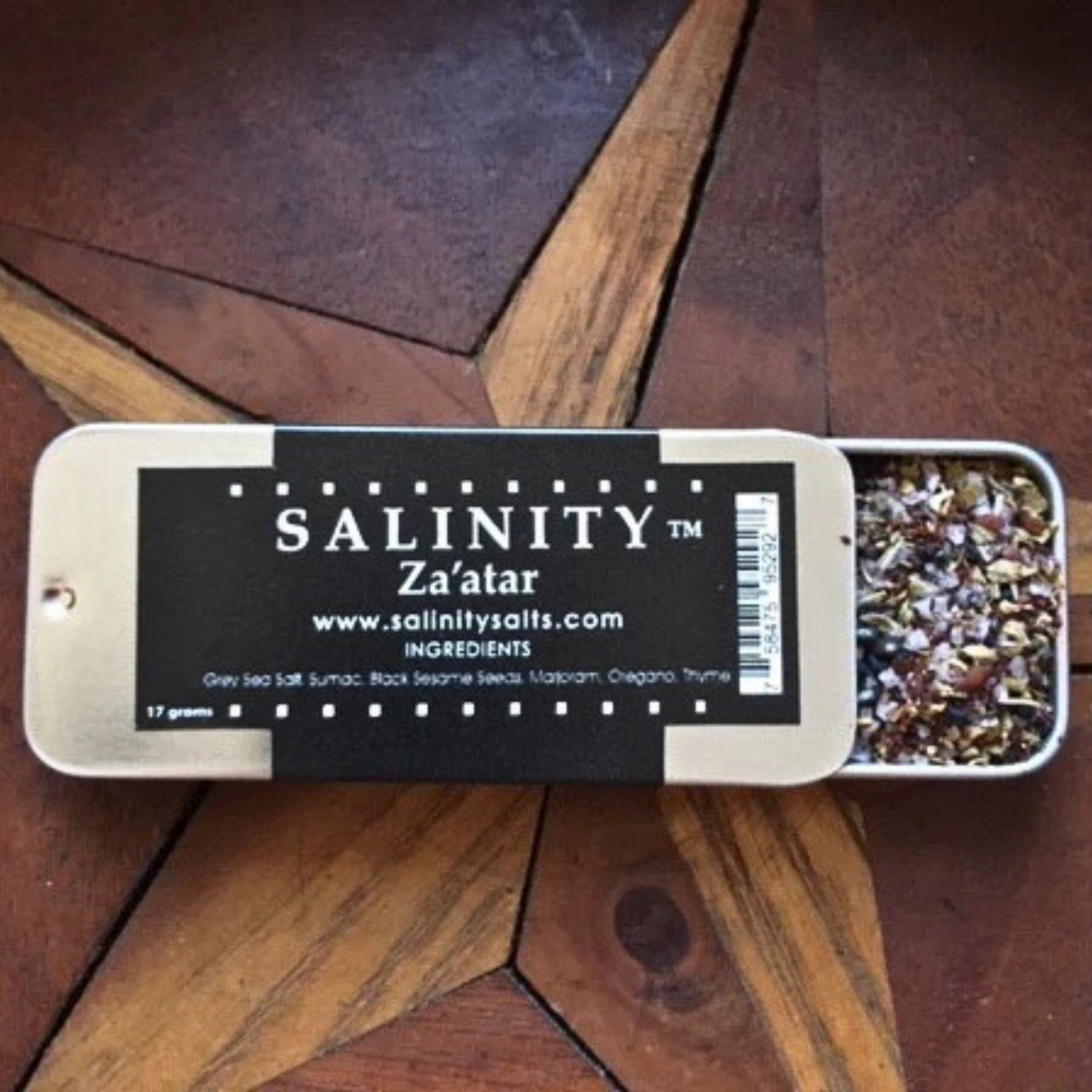 Small metal container open to show contents on a wooden surface