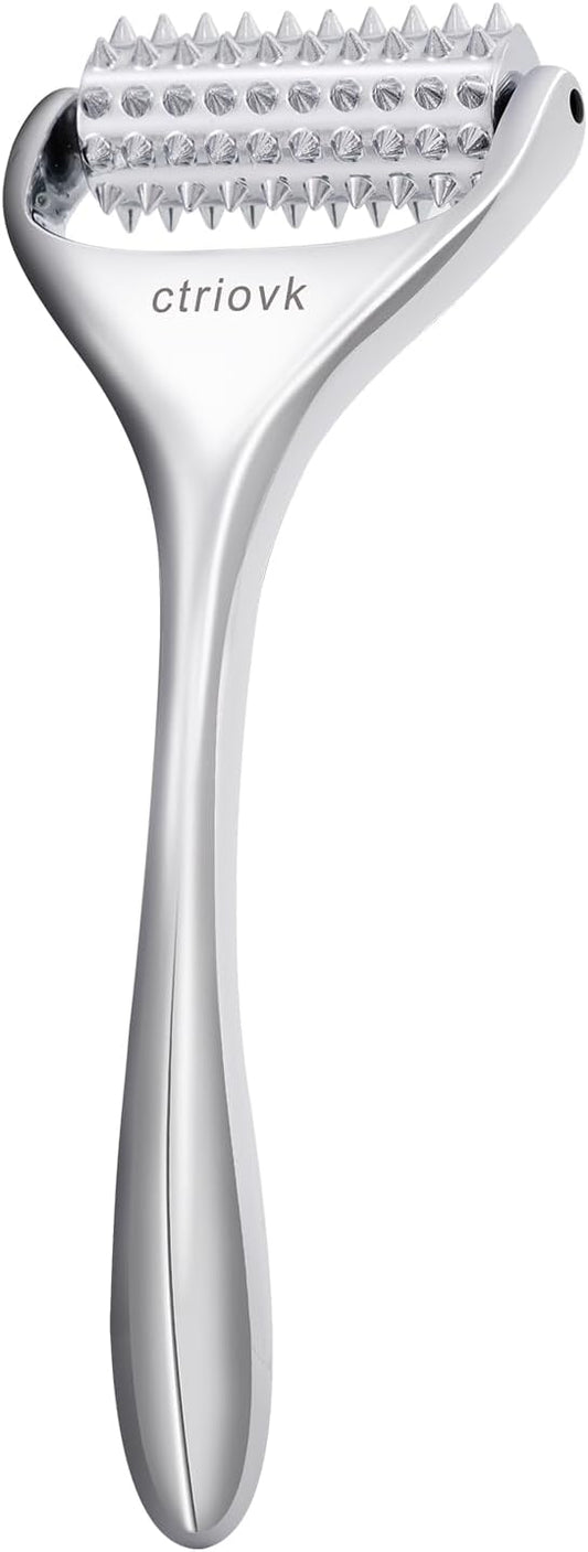 Metallic skin massage tool with a handle on a white background