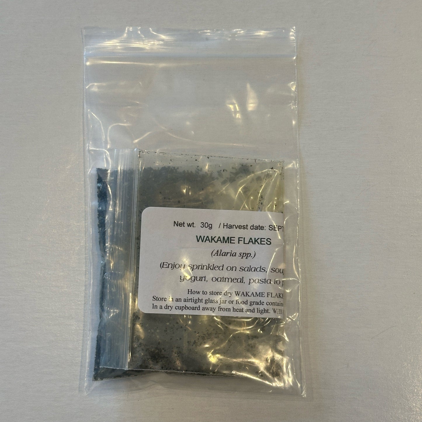 Small package of Wakame flakes with a label on a white background