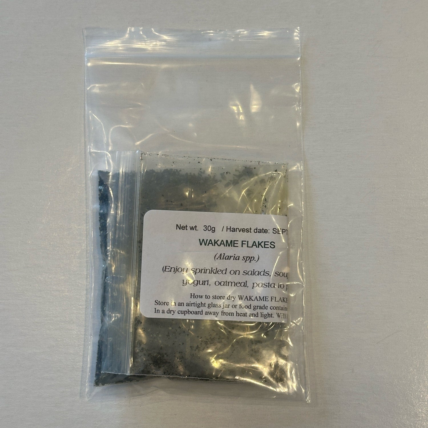 Small package of Wakame flakes with a label on a white background