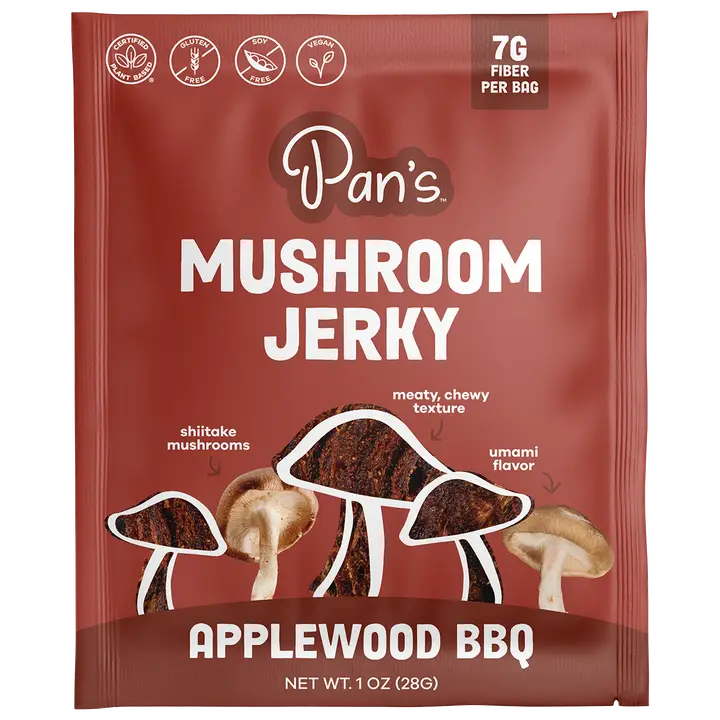A single packet of Pan's Mushroom Jerky, Applewood BBQ flavor, 1 oz (28g). The packaging is dark reddish-brown with white text and illustrations of shiitake, meaty chewy, and umami mushrooms.