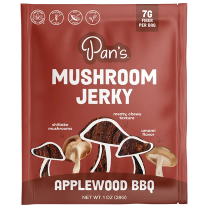 A single packet of Pan's Mushroom Jerky, Applewood BBQ flavor, 1 oz (28g). The packaging is dark reddish-brown with white text and illustrations of shiitake, meaty chewy, and umami mushrooms.