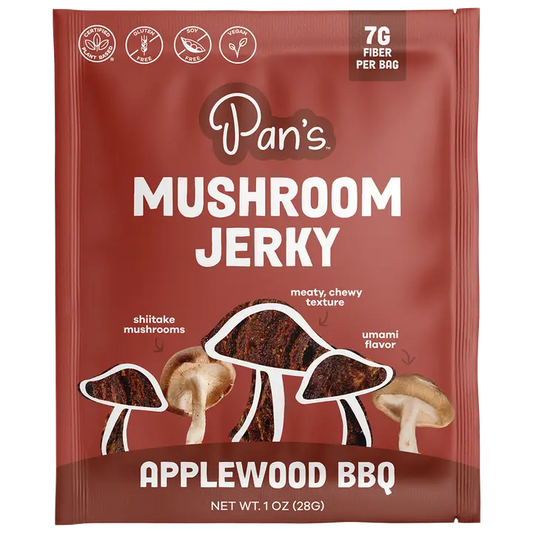 A single packet of Pan's Mushroom Jerky, Applewood BBQ flavor, 1 oz (28g). The packaging is dark reddish-brown with white text and illustrations of shiitake, meaty chewy, and umami mushrooms.