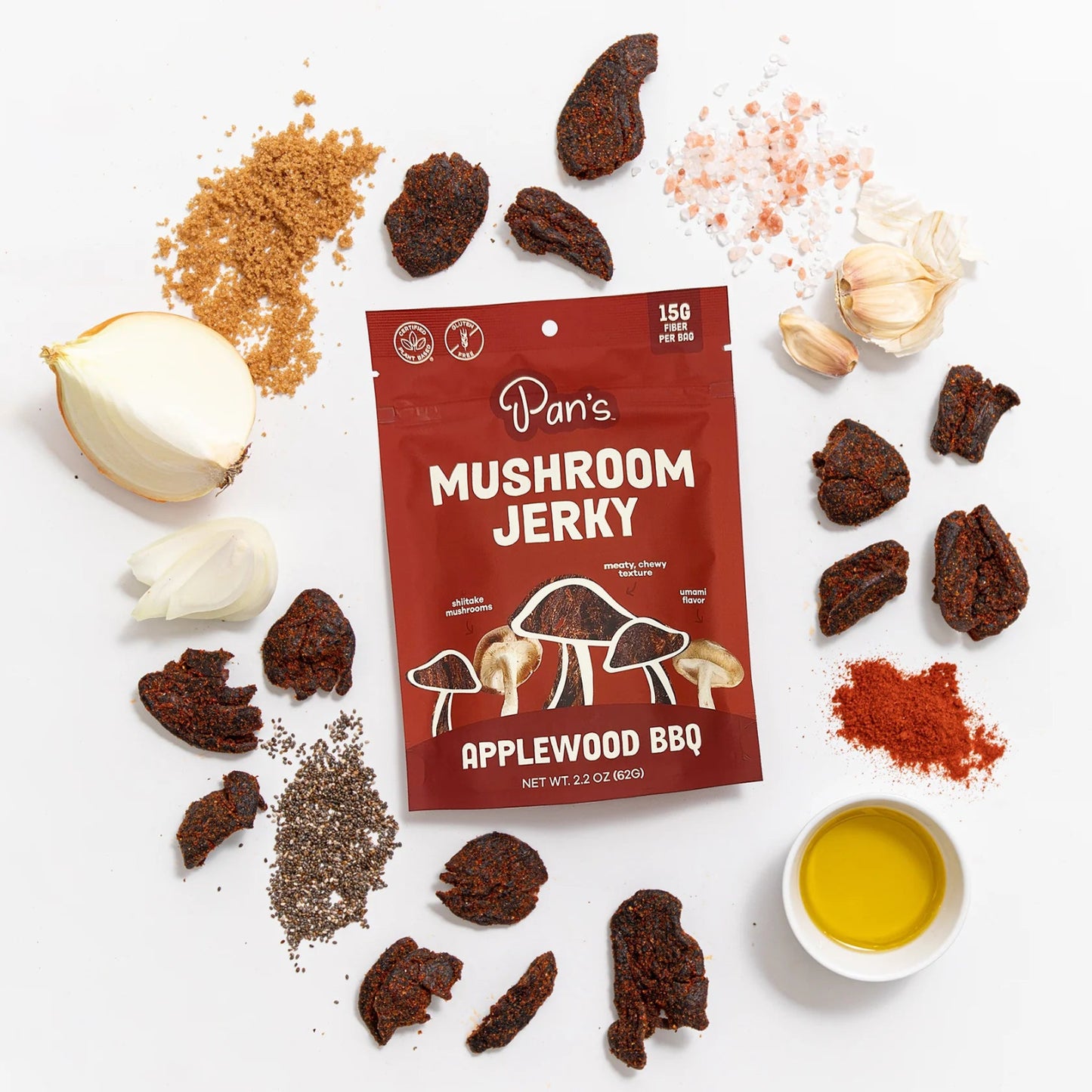 Pan's Mushroom Jerky Applewood BBQ package surrounded by ingredients on a white background