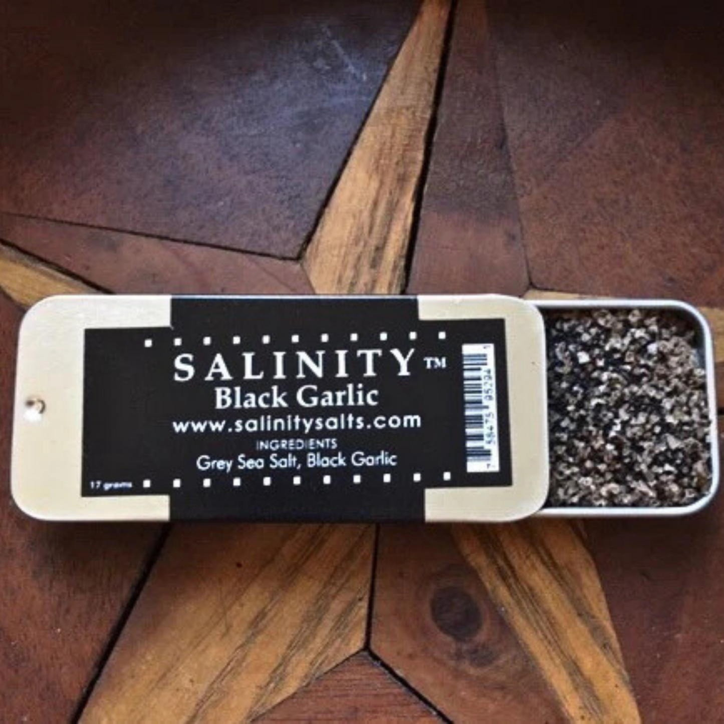 Small metal container open to show contents on a wooden surface