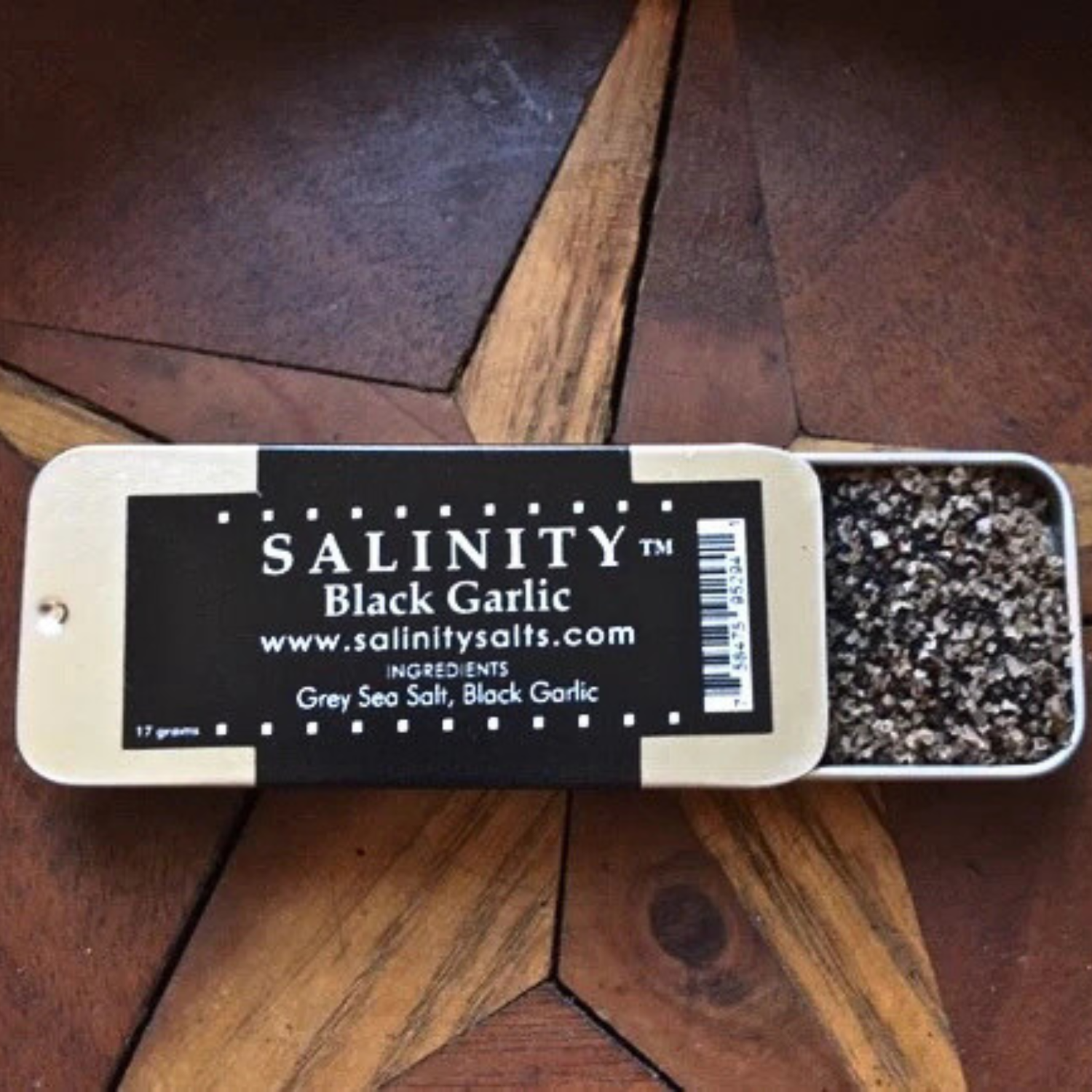 Small metal container open to show contents on a wooden surface