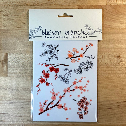 Pack of temporary tattoos with floral designs on a wooden surface