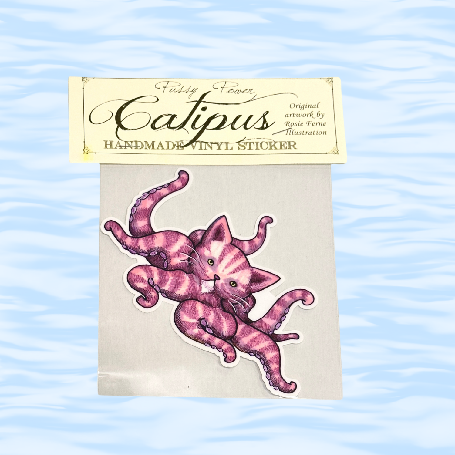 Pink cat-shaped vinyl sticker on a white card with 'Catipus' branding against a light blue wavy background.