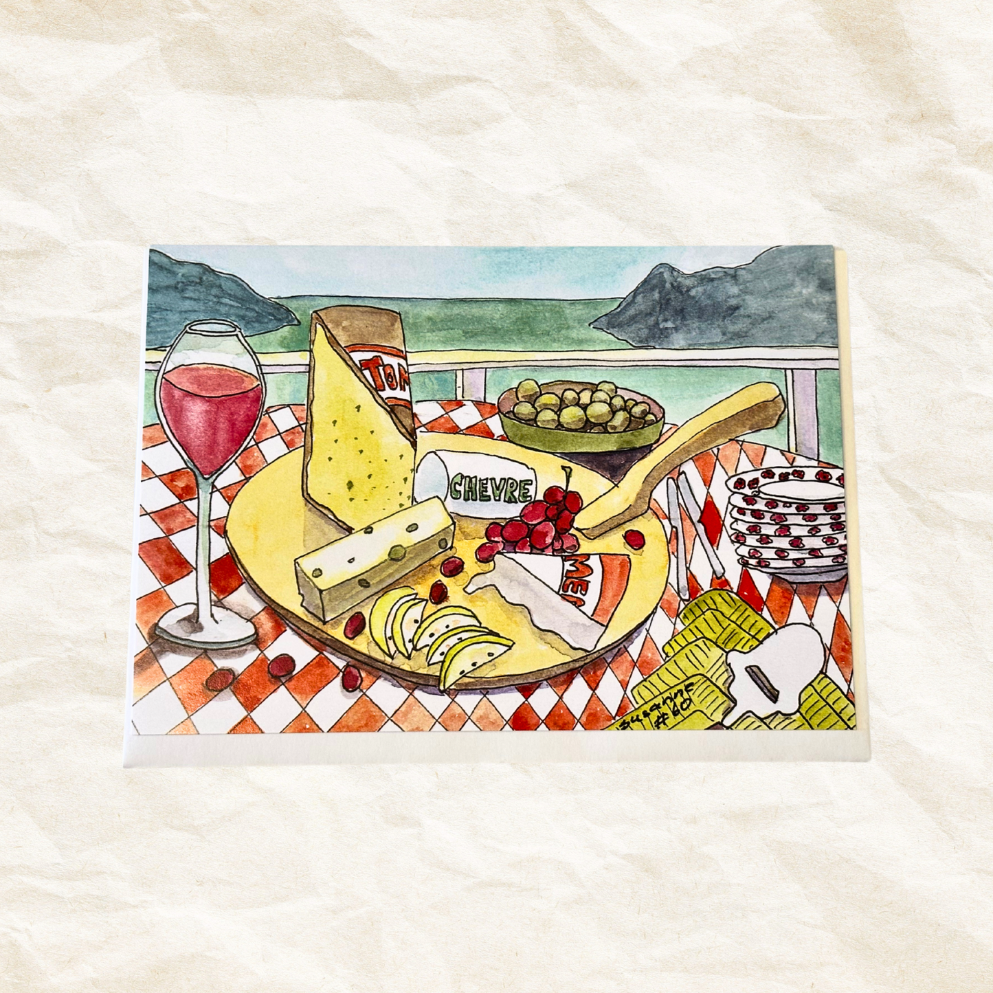 Illustration of a cheeseboard with wine and olives on a checkered tablecloth.
