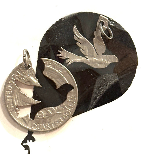 Two silver bird-shaped pendants on a black background