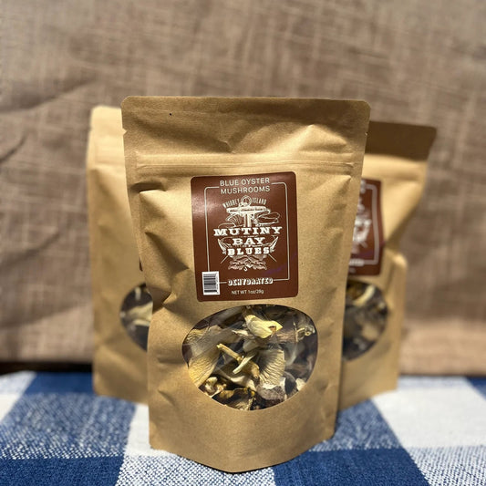 Kraft paper packaging with a clear window showing dried mushrooms on a blue and white checkered tablecloth.