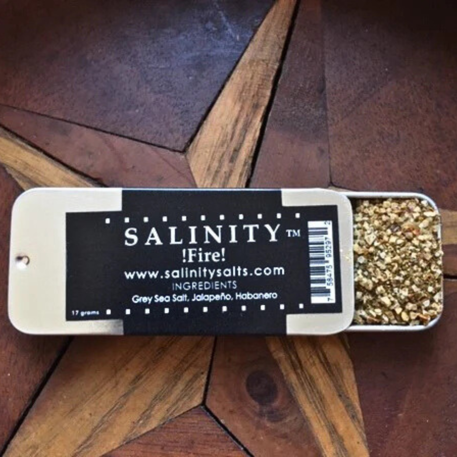 Small metal container open to show contents on a wooden surface