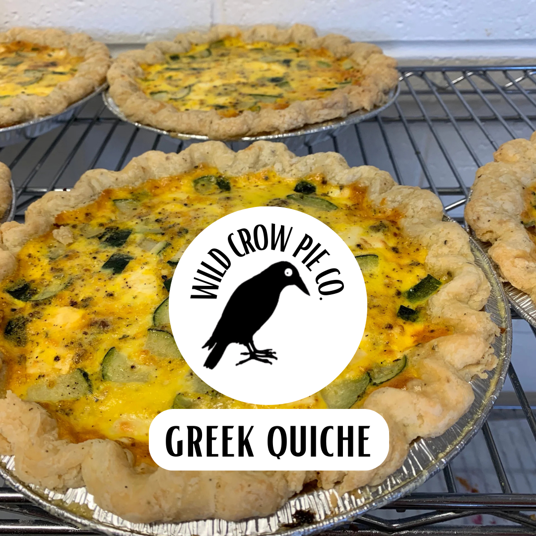 Greek quiche with Wild Crow Pie Co. logo on a cooling rack.