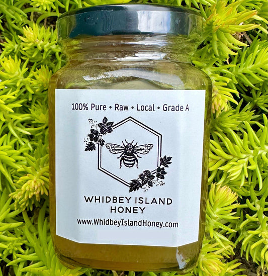 Jar of Whidbey Island Honey on a green leafy background