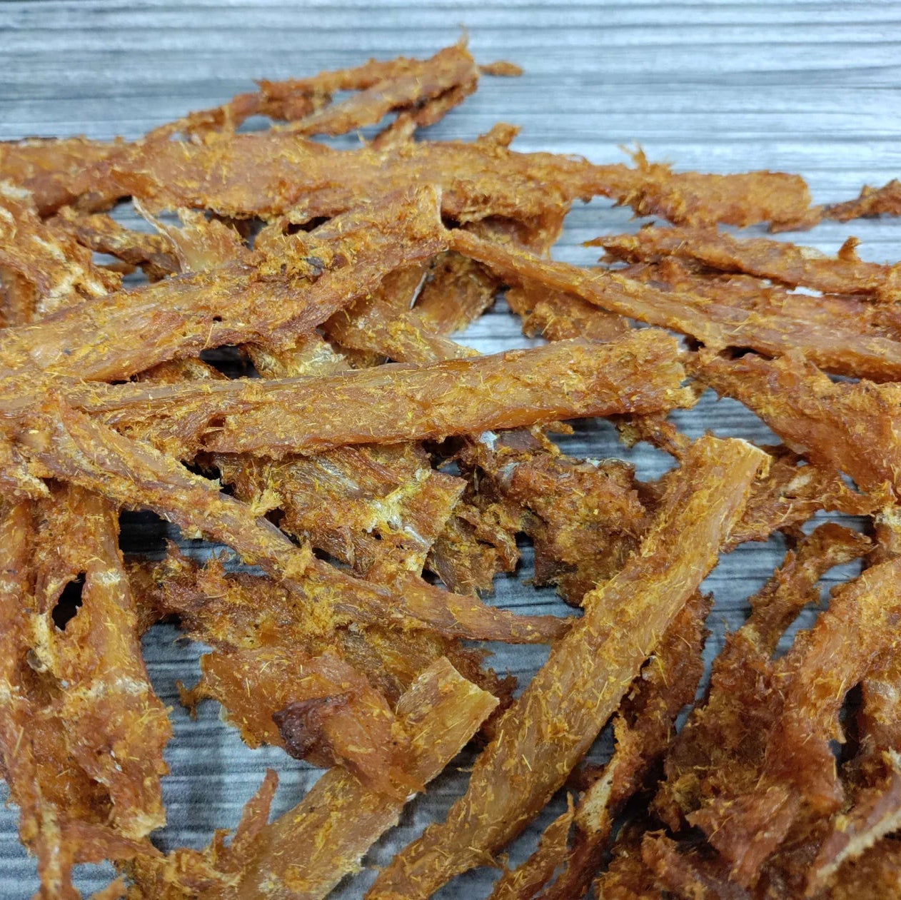 Dried cod fish jerky strips on a textured surface