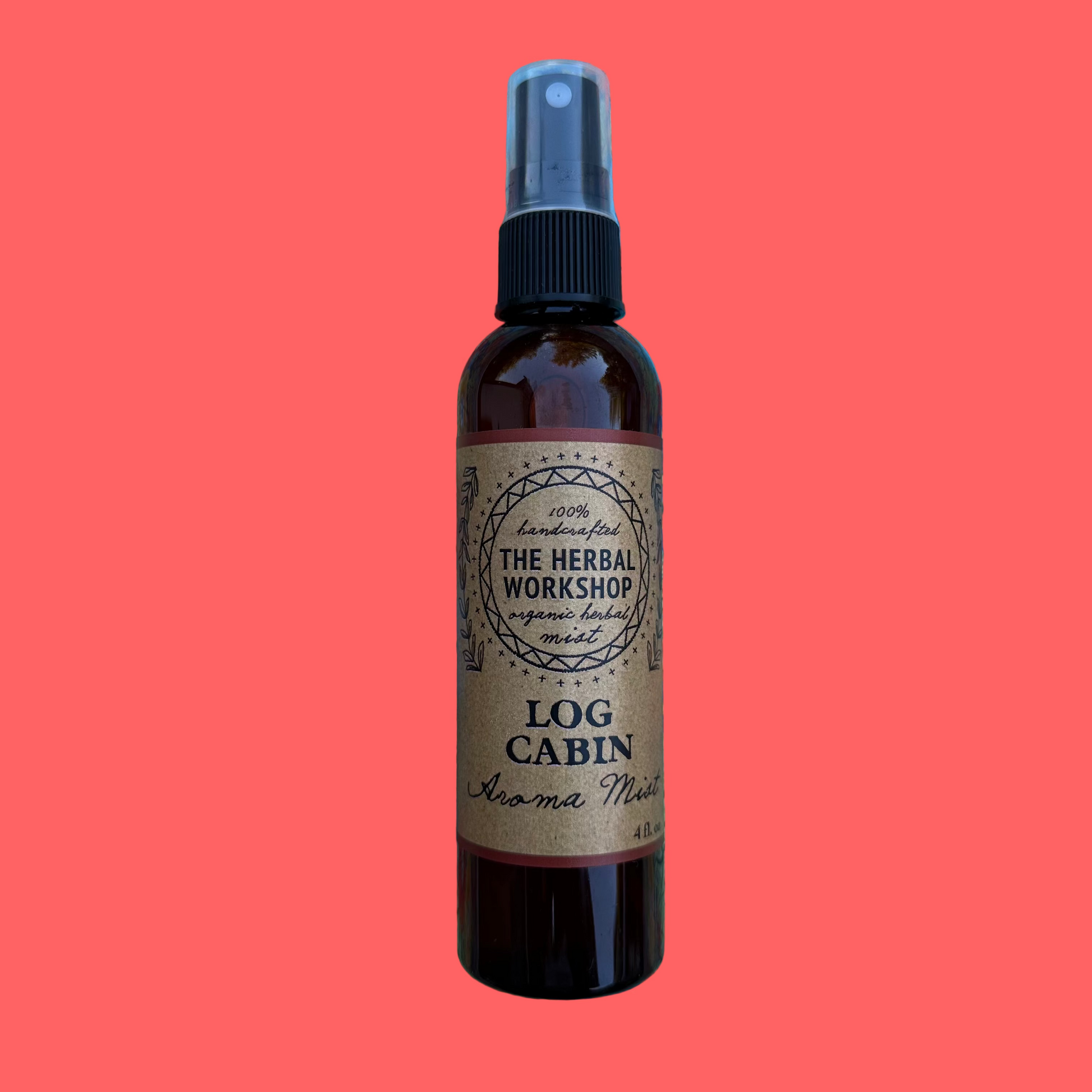 A brown spray bottle labeled 'Log Cabin' Aromatherapy Mist on a colorful floral background.