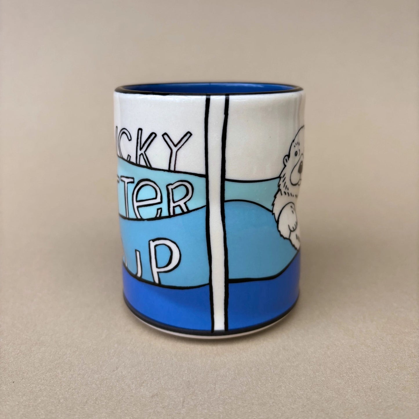Ceramic mug with a cartoon design of an otter and text on a beige background