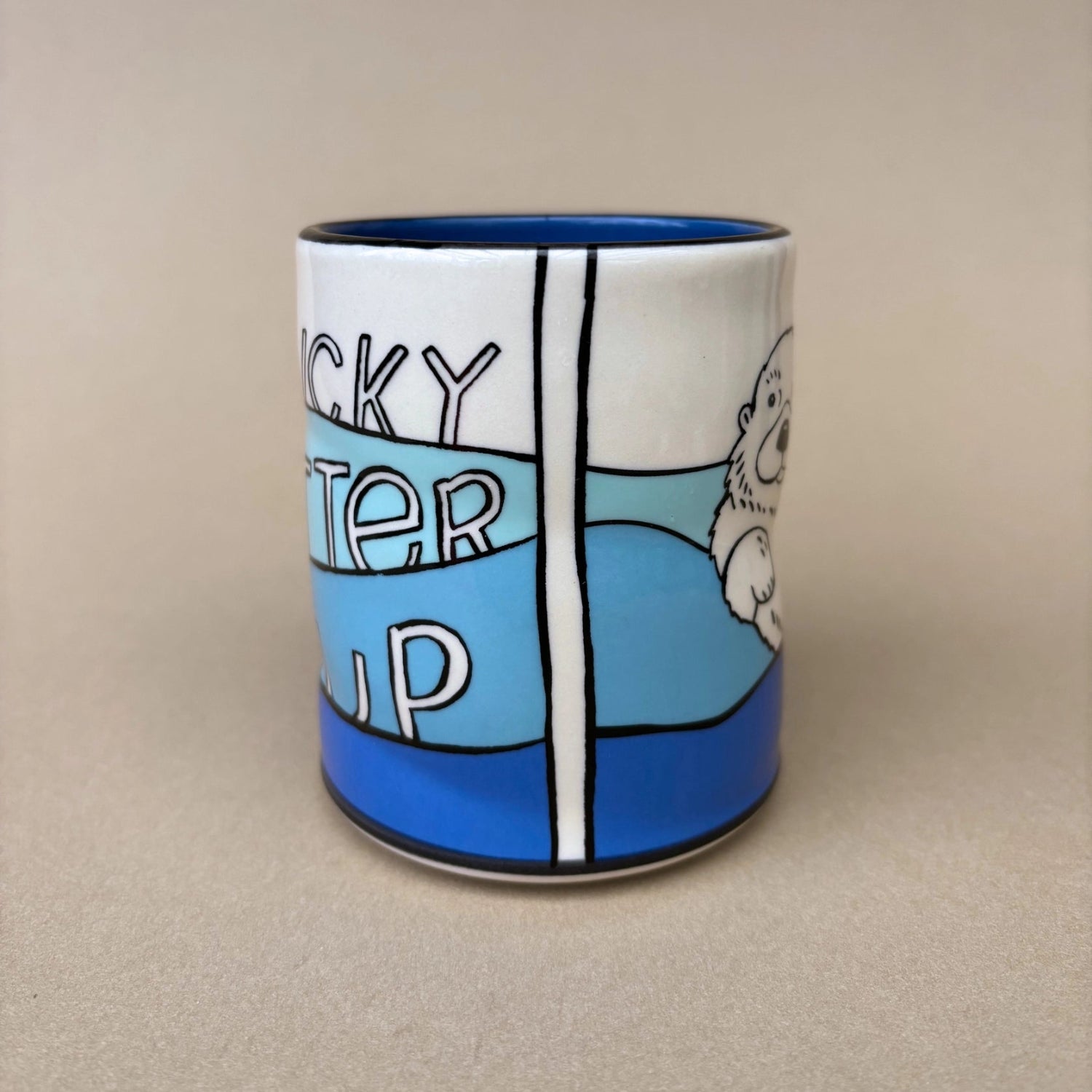 Ceramic mug with a cartoon design of an otter and text on a beige background