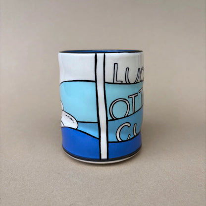 Ceramic mug with blue and white design on a beige background