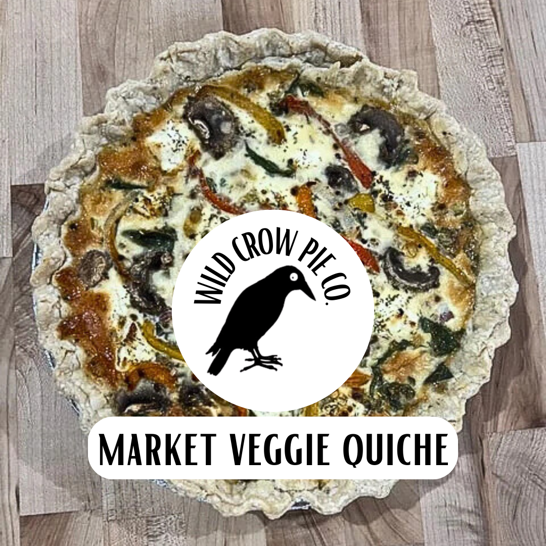 Market Veggie Quiche with Wild Crow Pie Co. branding on a wooden surface