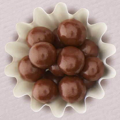 Chocolate covered hazelnuts in a white cup