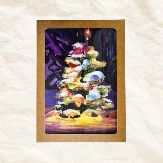 Colorful Christmas tree painting inside a brown box on a textured white surface