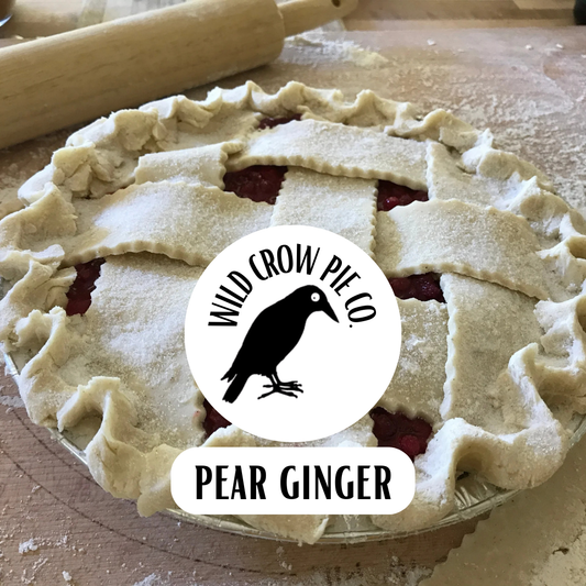 Pear ginger pie with lattice crust on a wooden surface, featuring Wild Crow Pie Co. branding.