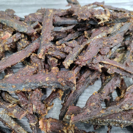 Dried salmon jerky strips on a metal tray