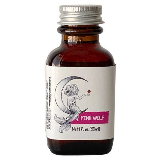 Small brown bottle with silver cap, with drawing of a mermaid sitting on a crescent moon, with the words "Aromatic / Pink Wolf / Net 1 fl oz (30 ml)"