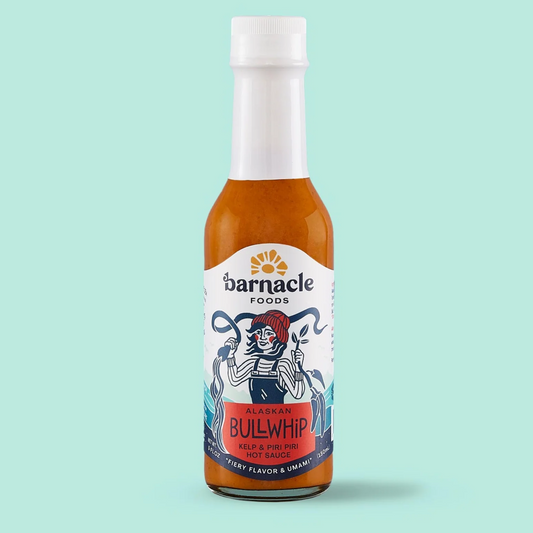 Bottle of Barnacle Foods Bullwhip hot sauce on a light blue background