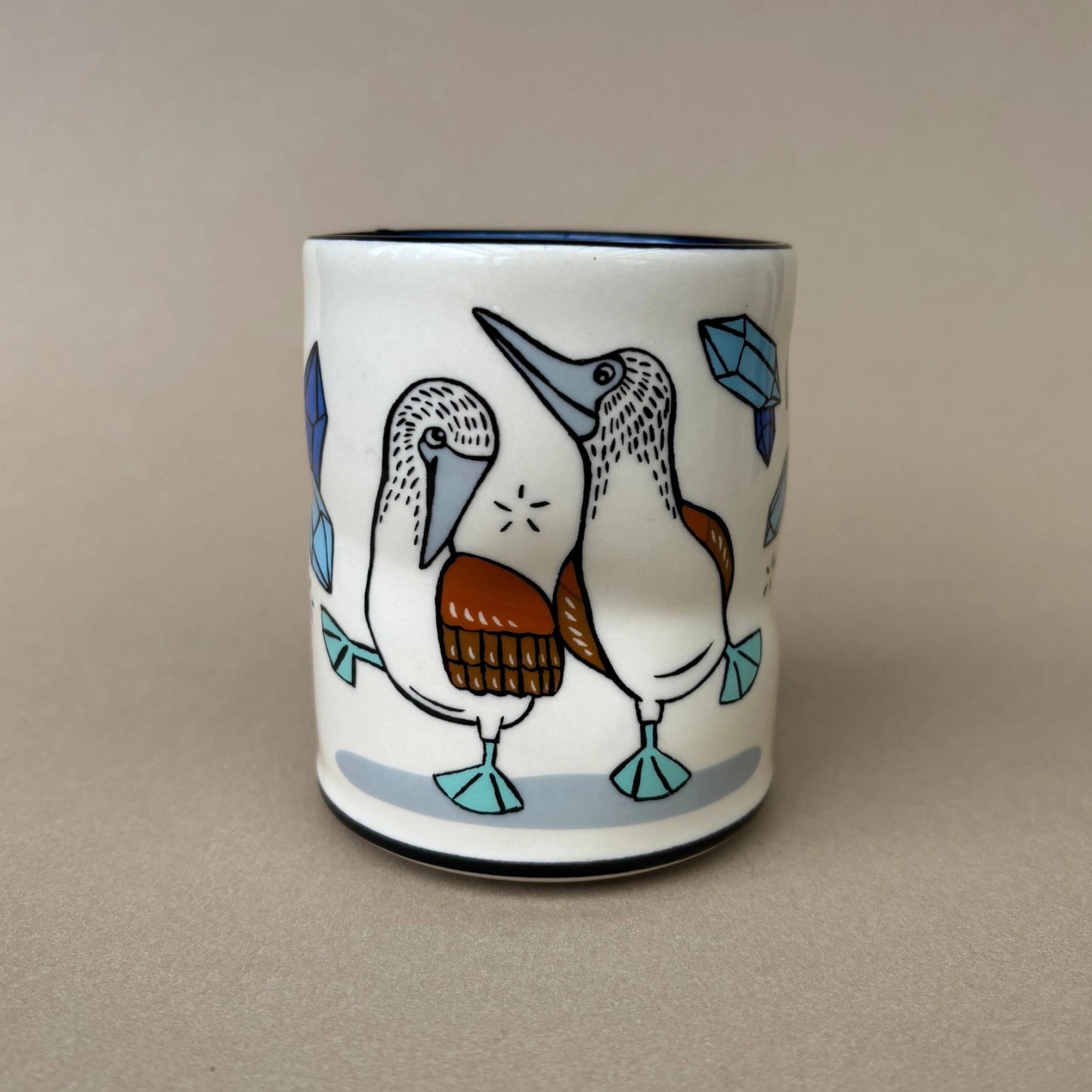 Ceramic mug with bird design on a beige background