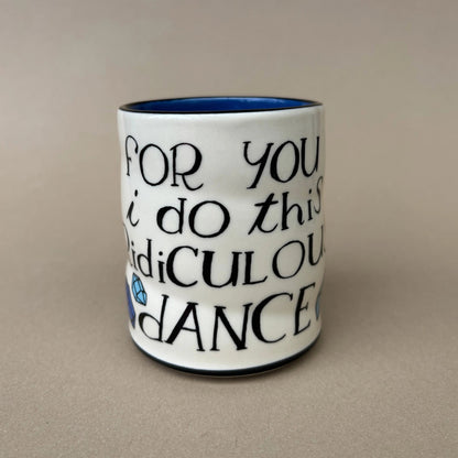 White mug with black text on a beige background