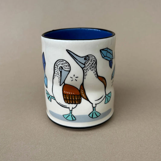 Ceramic mug with a bird design on a beige background