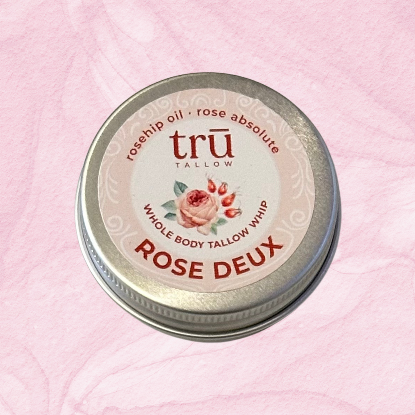 Tallow balm container labeled 'Rose Deux' on a pink background