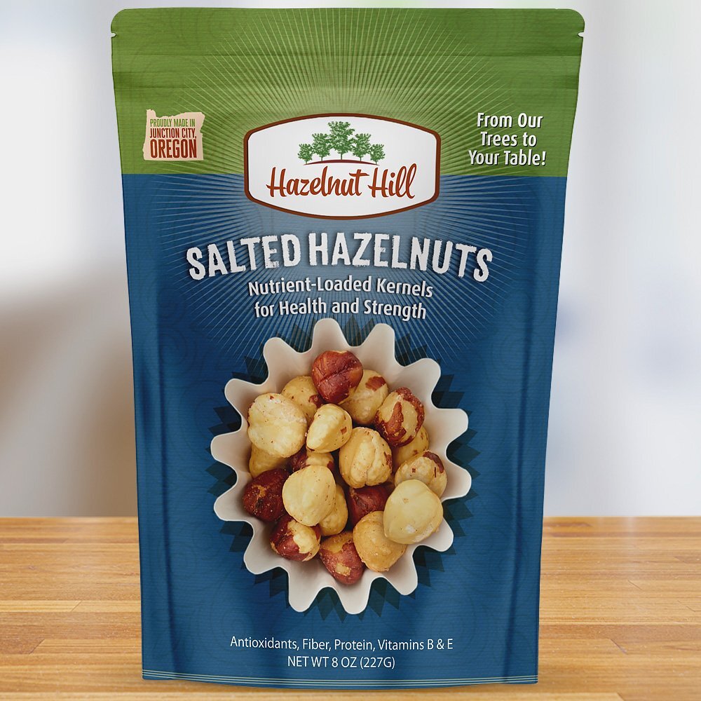 A package of Hazelnut Hill salted hazelnuts, with a picture of the hazelnuts on the front, indicating that they are roasted and salted. The package is labeled as vegan, gluten-free, and produced in Oregon.