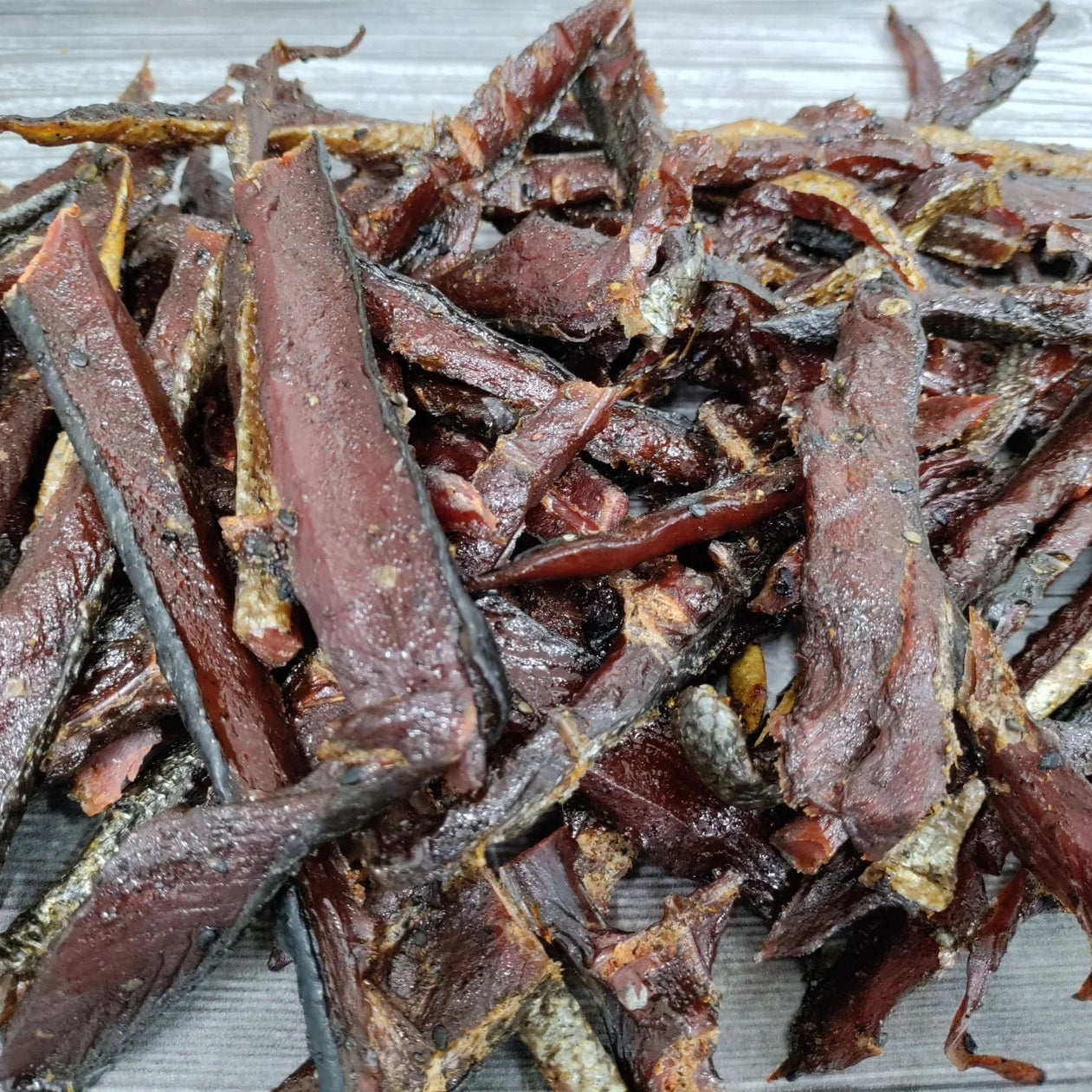 Dried salmon jerky strips on a white background
