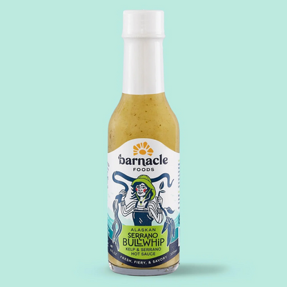 Bottle of Barnacle Foods Serrano Bullwhip sauce on a light blue background