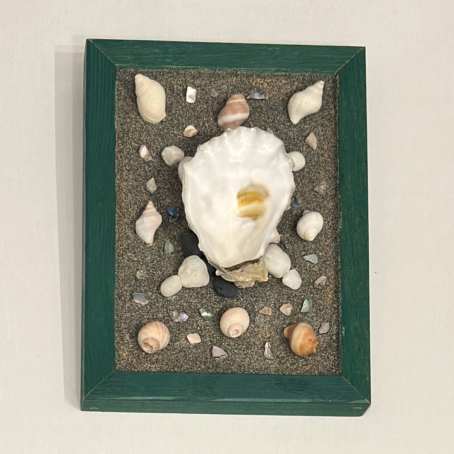 Decorative frame with seashells and sand on a light background