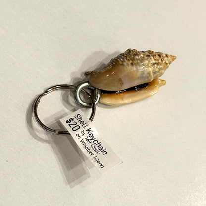 Shell keychain with a price tag on a light gray background