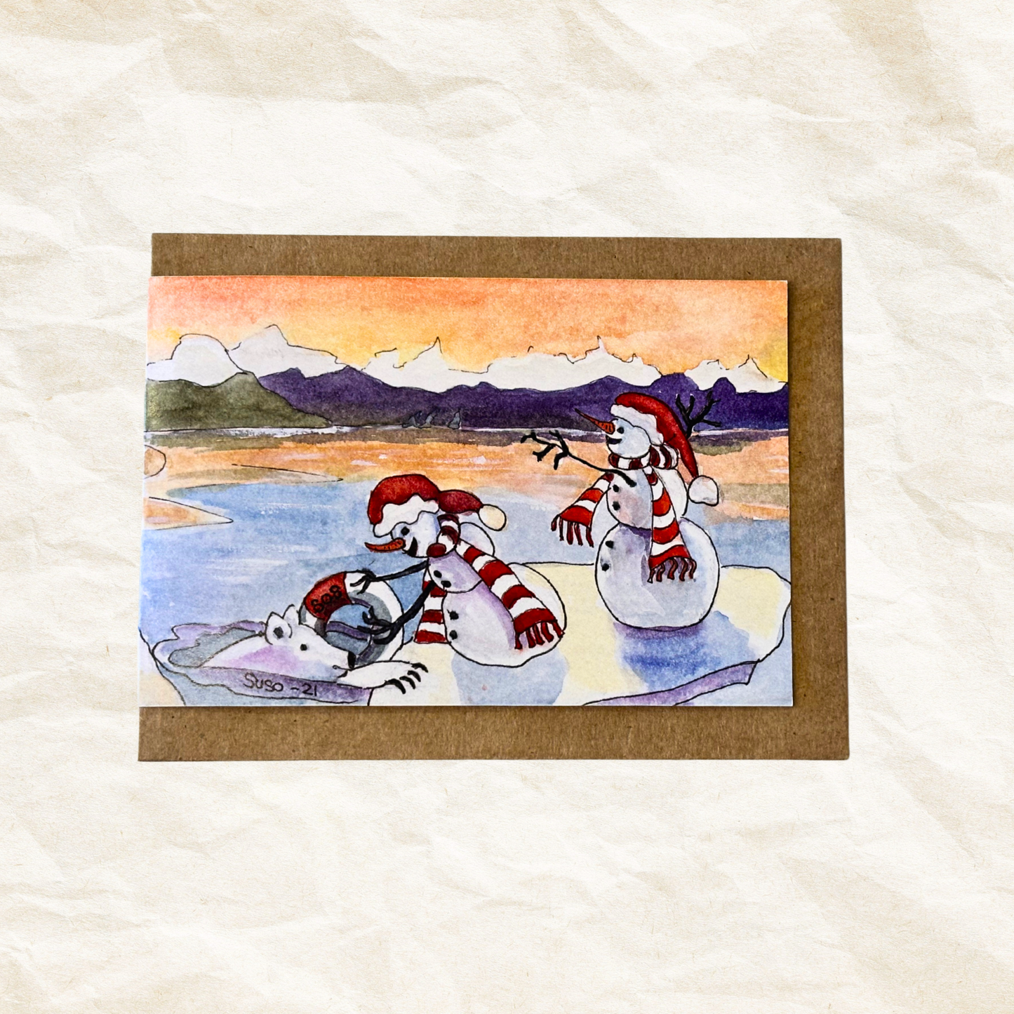 Illustration of a polar bear and snowman on ice with mountains in the background, on a textured white surface.
